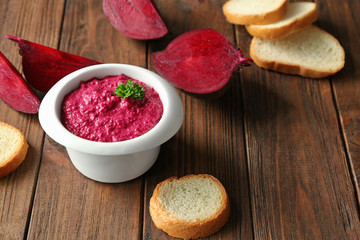 Bowl with delicious creamy beet hummus on table