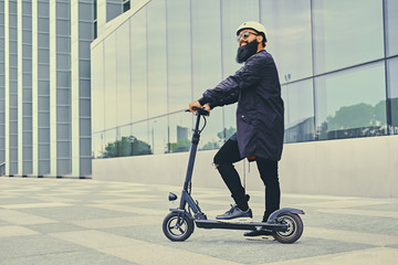 A man posing on electric scooter.