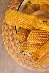 Close up view of section of wax honeycomb from beehive on the vintage wooden background. Honey is beekeeping healthy produce. Bee honey collected in the yellow beautiful honeycomb.