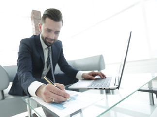 finance manager working with business graphics on a laptop