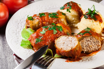Stuffed cabbage with meat and rice served with boiled potatoes and tomato sauce