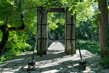 Entrance to the wooden bridge, under the trees