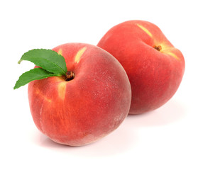 Two peaches with green leaf isolated on white background