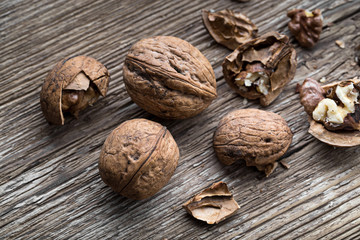 Walnuts on a wooden aged rustic background. Broken, crushed walnuts