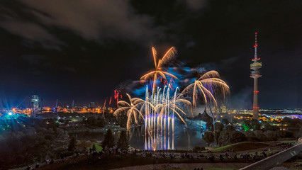 Buntes, spektakuläres Feuerwerk über der Stadt München im Olympiapark vom Olympiaberg aus in der Nacht im Sommer