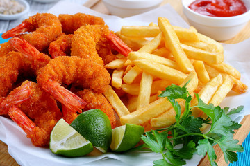 breaded Fried Shrimps, limes and french fries