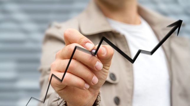 Businessman drawing hand-drawn arrow going up