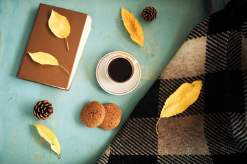 Old book, knitted sweater with autumn leaves and coffee mug