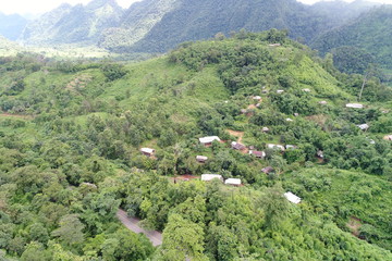Top view or Aerial view of landscape village countryside and green field, Thailand on green trees nature and mountain background - Take a photo by drone camera