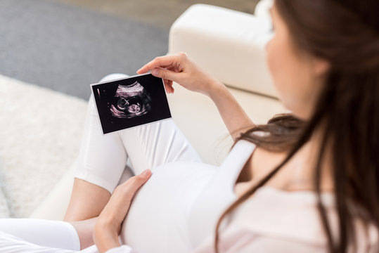 Pregnant woman looking at ultrasound picture