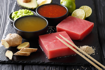 Raw fresh tuna fillet with chili and pineapple sauces and other ingredients close-up. Horizontal