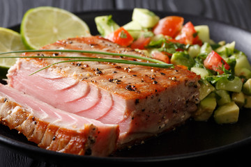 Lime Grilled Tuna with Avocado Cucumber Salsa closeup on a plate. horizontal