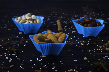 Bowls of various legumes and seeds. Lentils, sesame seeds, pistachio nuts, flaxseed, peanuts and chickpeas. Sprouted legumes. Wooden background