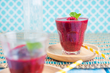 Berry Smoothie with Mint, black currant, red currant, raspberry and blueberry on blue wooden table