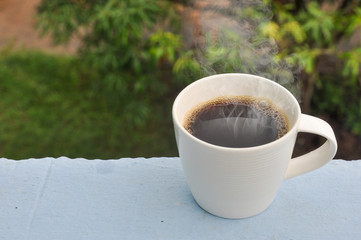 white hot coffee cup of green natural background