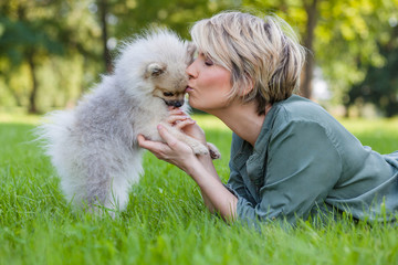 Frau küsst ihren süßen Zwergspitz Hund