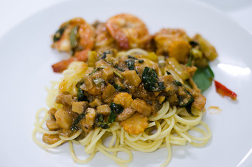 Delicious spaghetti with shrimps and basil on a white background.