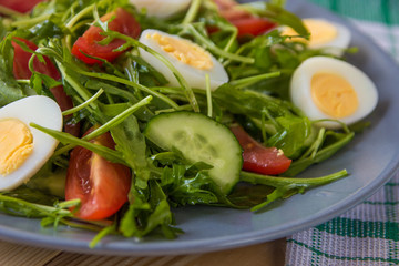 Fresh green salad with arugula, tomatoes, eggs and cucumber