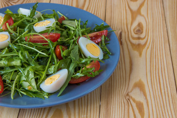 Fresh green salad with arugula, tomatoes, eggs and cucumber