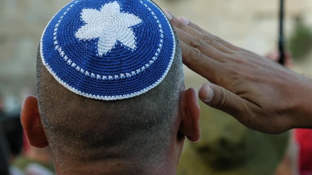 Israeli soldier military man saluting to the Western wall in Jerusalem. Western wall or Wailing wall or Kotel is the most sacred place for all jewish people.