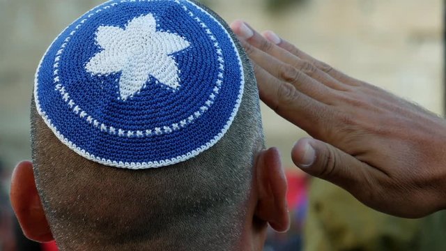 Israeli soldier military man saluting to the Western wall in Jerusalem. Western wall or Wailing wall or Kotel is the most sacred place for all jewish people.