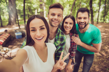 Selfie time1 Close up of four cheerful  friends in the spring nice wood, embracing, posing for a selfie shot, that attractive brunette lady is taking