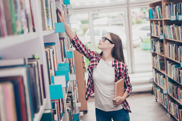 Side profile shot of young attractive girl student bookworm, studying in the ancient university`s...