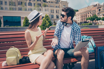 Young married couple got lost on vacation in town. Frustrated lady is arguing with her boyfriend,...