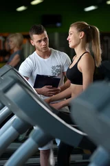 Foto op Plexiglas Smiling female working with personal coach in gym © pavel_shishkin