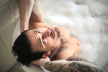 Attractive young man having a relaxing bath