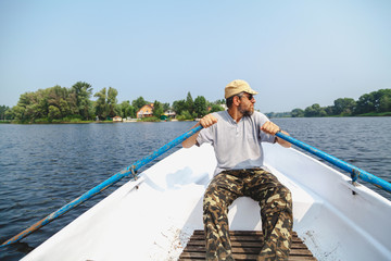 Fototapeta premium man with beard rowing on rowing boat