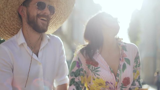 Young boho styled mexican people dancing on the city street, lens flare sun shining