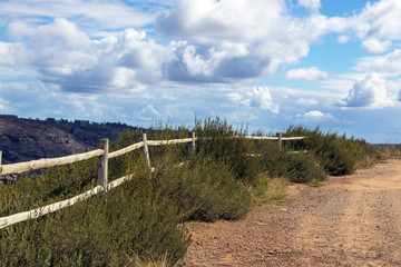 Fototapeta na wymiar Wooden Pole Fence Against Cloudy Sky in South Africa