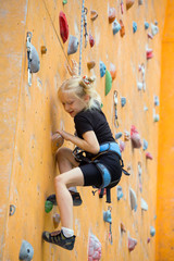  little girl climbing up the wall