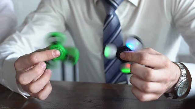 Young man playing with two fidget spinners. slow motion