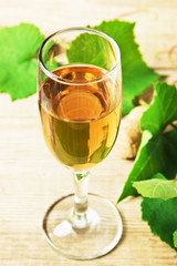 glass of wine and vine on  wooden table
