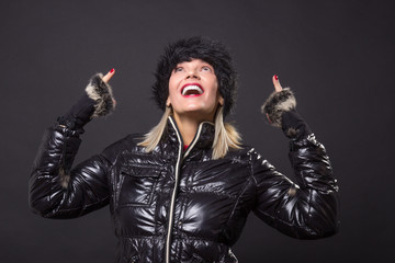 mature woman 40s happy smiling posing black winter jacket looking up above