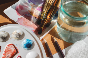 Artist table with watercolor pallete and brushes. Creativity concept.