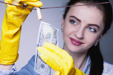 Laundering and legalization of money. Beautiful young woman washes money. (Shadow money, bribe,...