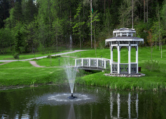 Obraz premium Arbor with a bridge on a pond