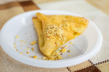 Pancake with nuts on a plastic plate