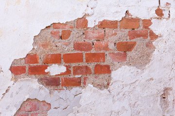 An old wall with opaque plaster and visible bricks.