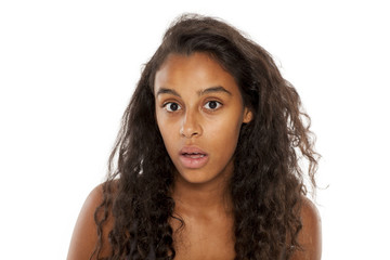 Shocked dark skinned young girl on white background