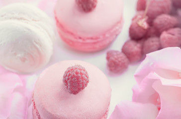 Pink and white Macaroni with raspberries and a beautiful rose flower. Dessert close-up.