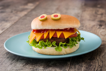 Halloween burger monsters on wooden table
