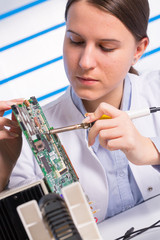 Young woman fix PC component in service center