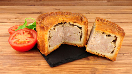 Crusty savoury pork pie on a wood background