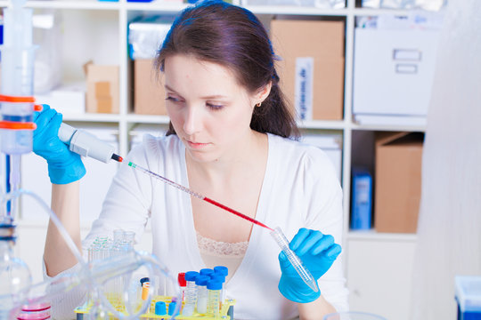 Female laboratory technician going blood test in medical laboratory