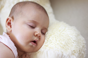 Bebé durmiendo sobre un peluche