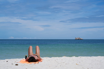 Fototapeta na wymiar Women sunbathing on beaches with beautiful blue sky.
